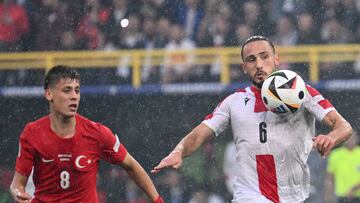 Georgia's midfielder #06 Giorgi Kochorashvili runs with the ball past Turkey's forward #08 Arda Guler during the UEFA Euro 2024 Group F football match between Turkey and Georgia at the BVB Stadion in Dortmund on June 18, 2024. (Photo by Alberto PIZZOLI / AFP)