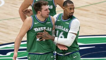 Dallas Mavericks guard Luka Doncic (77) is held back by forward James Johnson (16) as he argues with referees after being called for a technical foul during the first half of an NBA basketball game against the Orlando Magic, Saturday, Jan. 9, 2021, in Dallas. (AP Photo/Jeffrey McWhorter)