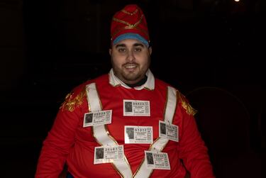 Un hombre con décimos de lotería en su jersey antes del comienzo del Sorteo Extraordinario de la Lotería de Navidad 2023.