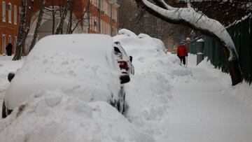 A man walks past cars covered with snow after heavy snowfall in Moscow, Russia December 15, 2023. REUTERS/Maxim Shemetov