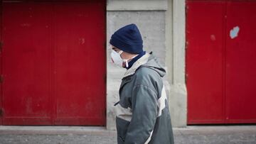 Una persona con mascarilla en la calle el d&iacute;a en el que entra en vigor la limitaci&oacute;n total de movimientos salvo de los trabajadores de actividades esenciales