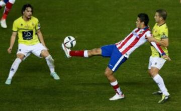 El delantero mexicano del Atlético de Madrid Raúl Jiménez (c) controla el balón entre el centrocampista Alejandro Barrera (i) y el defensa José Rodríguez (d), de L'Hospitalet, durante el partido de vuelta de los dieciseisavos de final de la Copa del Rey que se juega esta tarde en el estadio Vicente Calderón. 