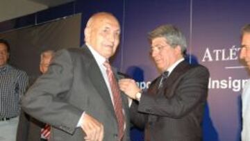 Enrique Cerezo le entrega la insignia a un socio del Atlético
