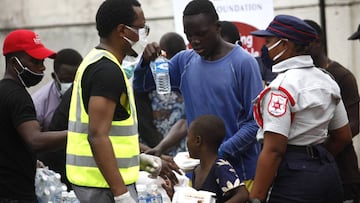 Lagos (Nigeria), 14/05/2020.- People collect food items at a makeshift food distribution centre organized by BUA Foundation along a road in Victoria Island, Lagos, Nigeria, 14 May 2020. During the last week, lockdowns are eased in Lagos as numbers of infe