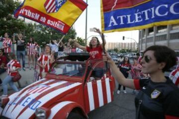 Aficionados del Atlético de Madrid animan a su equipo durante el recorrido.