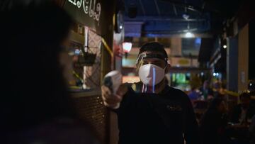 Un trabajador de un restaurante en Brasilia toma la temperatura de uno de los clientes.