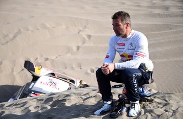 El piloto francés Sebastien Loeb sentando cerca de su coche averiado en la arena que le obligó a retirarse del Dakar 2018 en la quinta etapa entre San Juan De Marcona y Arequipa en Perú.