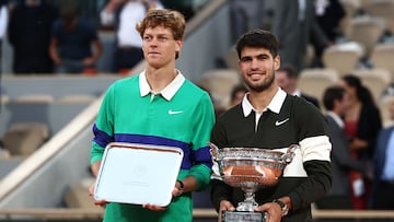 Winner Spain's Carlos Alcaraz (R) poses with the trophy next to Italy's Jannik Sinner at the end of their men's singles final match on day 15 of the French Open tennis tournament on Court Philippe-Chatrier at the Roland-Garros Complex in Paris on June 8, 2025. (Photo by Thibaud MORITZ / AFP)