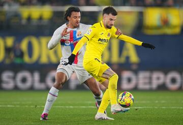 Jules Kounde del FC Barcelona lucha por la posesión con Alex Baena del Villarreal CF.