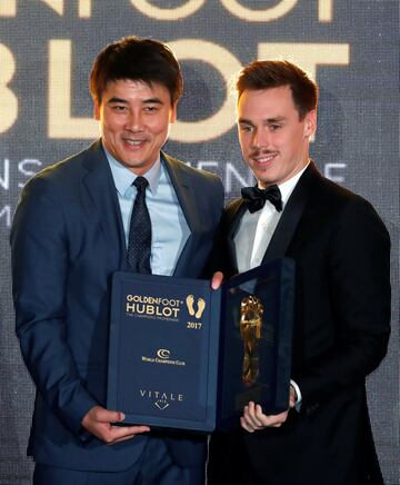 Li Ming posa con el Golden Football Legend Award y con Louis Ducruet.