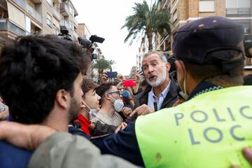 El rey Felipe VI de España habla con la gente durante su visita a Paiporta, tras las fuertes lluvias que provocaron inundaciones, en Paiporta.