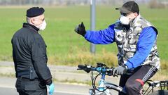 Un carabinieri habla con un hombre que rueda en bicicleta en los alrededores de Castiglione d&#039;Adda, uno de los pueblos de Italia aislados por el brote de coronavirus.