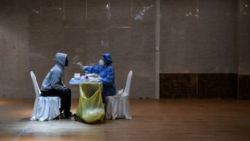 A health worker takes a swab sample from a journalist to be tested for Covid-19 Coronavirus, the night before the 14th Committee of the Chinese People's Political Consultative Conference (CPPCC) in Beijing on March 3, 2023. (Photo by NOEL CELIS / AFP) (Photo by NOEL CELIS/AFP via Getty Images)