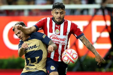 Alexis Vega (R) of Guadalajara vies for the ball with Pavel Perez of Pumas during their Mexican Apertura tournament football match, at the Akron stadium in Guadalajara, Jalisco State, Mexico, on August 27, 2022. (Photo by Ulises Ruiz / AFP)