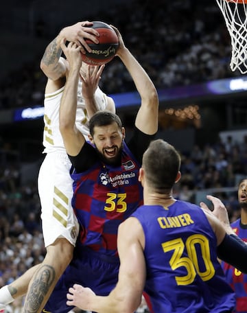 El jugador del Barcelona, Mirotic, pelea un balón con un jugador del Real Madrid. 