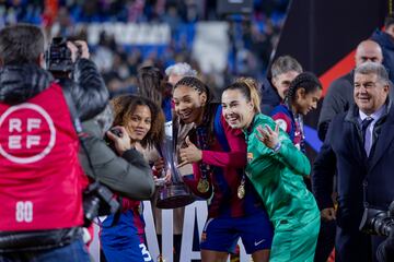 El presidente del FC Barcelona, Joan Laporta, observa como Vicky López, Salma Paralluelo y Cata Coll posan con el trofeo de la Supercopa de España para los medios de comunicación.