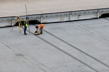 Operarios relizan diversas tareas en la instalación de butacas, vallas de vidrio y pantallas, así como cambios en la instalación de las bandejas del césped.