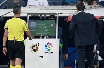 Spanish referee Santiago Jaime Latre (L) and Real Madrid's Spanish coach Julen Lopetegui check the VAR screen during the Spanish league football match between Real Madrid CF and Club Deportivo Leganes SAD at the Santiago Bernabeu stadium in Madrid on Sept