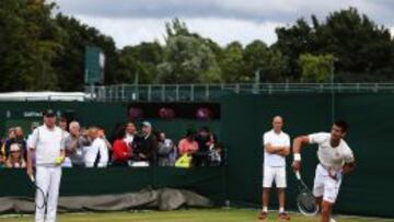 Novak Djokovic hizo ayer un último ensayo, rodeado de público y ante la atenta mirada de Boris Becker (izda.), el excampeón que ahora guía sus pasos.
