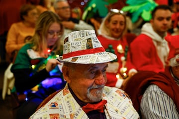 Un hombre disfrazado con décimos de lotería antes del comienzo del Sorteo Extraordinario de la Lotería de Navidad 2023.