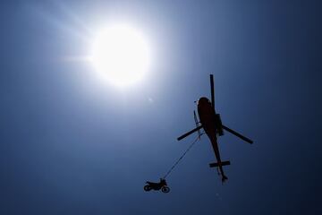 Un helicóptero transporta la moto del piloto francés Charlie Herbst.