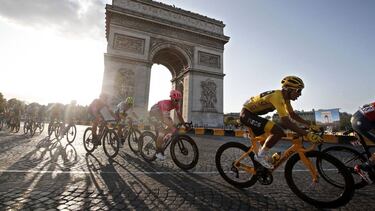 Paris (France).- (FILE) - Colombia's Egan Bernal (R) of Team Ineos wears the overall leader's yellow jersey as he passes with the pack by the Arc de Triomphe during the 21st and final stage of the 106th edition of the Tour de France cycling race over 128k
