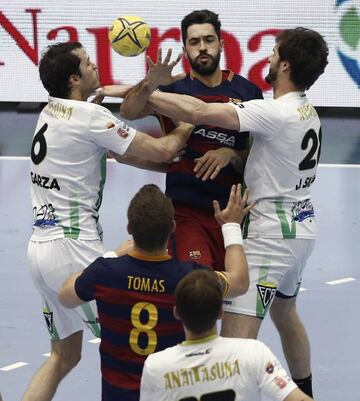 El jugador del Barcelona Raul Entrerrios (c) lanza a porteria ante los jugadores del Helvetia Anaitasuna Alejandro Garza (i) Jorge Fiipe (d), durante el partido de la final de la XLI Copa del Rey de Balonmano que se disputa en el pabellón Anaitasuna de Pamplona.