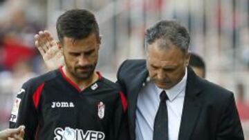 El entrenador del Granada, Joaqu&iacute;n Caparr&oacute;s, da &aacute;nimos a su jugador Javi M&aacute;rquez, que abandona el terreno de juego en su partido ante el Sevilla. 