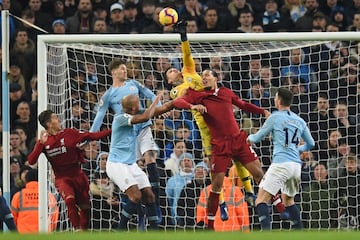 El portero del Manchester City Ederson trata de despejar un balón.