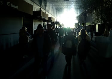 Aficionados caminan por las oscuras pasarelas durante un apagón generalizado durante la séptima jornada del Mutua Madrid Open en La Caja Mágica.