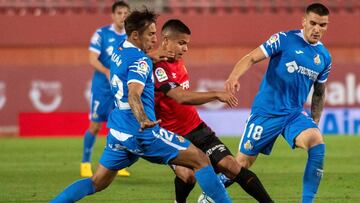 El delantero colombiano del Mallorca Cucho Hernández (c) lucha con los uruguayos Mauro Arambarri (d) y Damián Suárez (i), ambos del Getafe, durante el partido de la 26ª jornada de LaLiga que se disputa hoy domingo en el estadio d