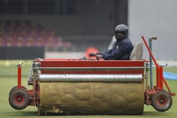 Un trabajador pasa una máquina para secar el césped para el partido de Cricket entre India y Sudáfrica.