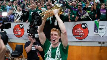 Alberto Díaz, capitán del Unicaja, levanta el trofeo de la Copa con los aficionados cajistas a su espalda.