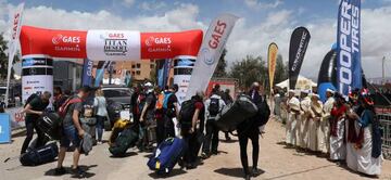 Los corredores de la Titan Desert 2018 recogen sus bicis y su equipaje al llegar al primer campamento.