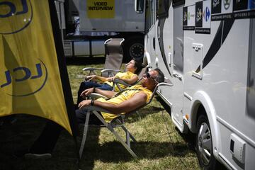 Empleados se relajan y toman el sol en la zona t¨¦cnica cercana a la meta durante la 12? etapa.