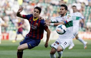 El delantero del Elche Ferrán Corominas lucha un balón con el defensa del  Barcelona Marc Bartra.