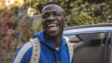 El futbolista Vinicius J&uacute;nior ri&eacute;ndose al lado de un coche.