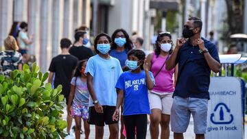 Una familia con máscaras faciales camina en un centro comercial en Miami Beach, Florida, el 29 de junio de 2020.