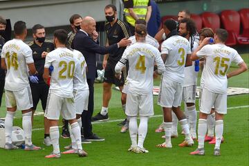 El técnico francés del Real Madrid charla con sus jugadores en la pausa para hidartarse en la primera mitad.