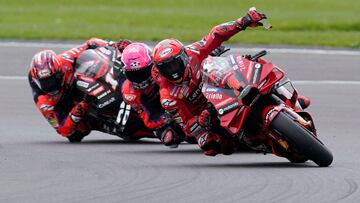 Bagnaia quitándose el protector de la visera delante de Aleix y Maverick.
