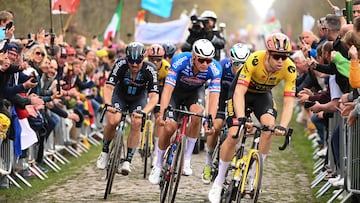 Jumbo-Visma team's Belgian rider Wout Van Aert (R) and Alpecin-Deceuninck team's Dutch rider Mathieu Van Der Poel (3-R) cycle with a pack of riders over the Trouee d'Arenberg cobblestone sector during the 120th edition of the Paris-Roubaix one-day classic cycling race, between Compiegne and Roubaix, northern France, on April 9, 2023. (Photo by Anne-Christine POUJOULAT / AFP)
