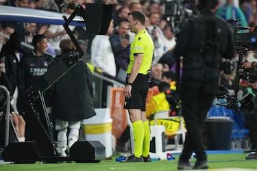 El árbitro Felix Zwayer revisa en el VAR la mano de Tsemikas dentro del área. El colegiado alemán, tras chequear la acción, mantiene su decisión de no señalar penalti.