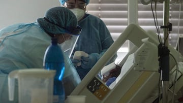 Nurses wearing personal protective equipments (PPE) treat a Covid-19 patient in an intensive care unit (ICU) at the Stod hospital on February 25, 2021 in Stod, Western Bohemia, amid the novel coronavirus / COVID-19 pandemic. - The Czech Republic is reaching capacity in intensive care wards as coronavirus infections keep soaring in the EU's worst-hit country, the health ministry said on February 23, 2021. The country tops the world in terms of new infections per 100,000 people over the last 14 days and is second after neighbouring Slovakia for deaths, according to an AFP tally. (Photo by Michal Cizek / AFP)