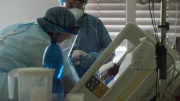 Nurses wearing personal protective equipments (PPE) treat a Covid-19 patient in an intensive care unit (ICU) at the Stod  hospital on February 25, 2021 in Stod, Western Bohemia, amid the novel coronavirus / COVID-19 pandemic. - The Czech Republic is reach