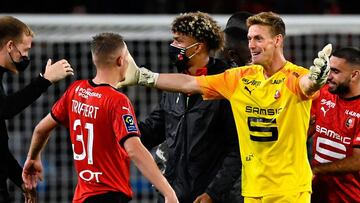 Stade Rennais' French defender Adrien Truffert (L) is congratulated by Stade Rennais' French goalkeeper Romain Salin during the French L1 football match between Stade Rennais Football Club and AS Monaco at the Roazhon Park stadium in Rennes, no