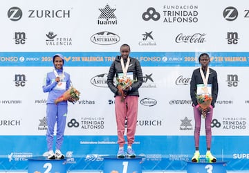 La keniana Agnes Ngetich celebra su victoria junto a la etíope Fotyen Tesfay, segunda posición, y la keniana Lilian Kasait , tercera posición, tras la media maratón de Valencia.