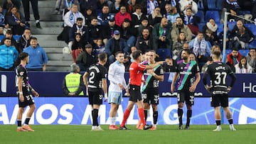 Los jugadores del Málaga CF rodean al árbitro tras el penalti pitado a Recio.
