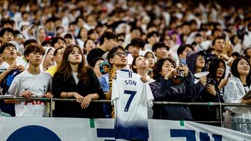 A spectator (C) holds a shirt cheering Tottenham Hotspur's captain Son Heung-min at the end of a friendly football match between Tottenham Hotspur and Newcastle United in Seoul on August 3, 2025. The 33-year-old South Korean striker said on August 2, that he will leave the club this summer after a decade in north London. (Photo by Anthony WALLACE / AFP)
