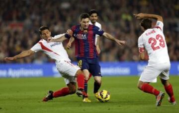 El delantero argentino del Barcelona Lionel Andrés Messi lucha el balón con el portugués Daniel Carriço y Jorge Andújar, del Sevilla FC, durante el partido correspondiente a la duodécima jornada de Liga que se disputa esta noche en el Camp Nou, en Barcelona.