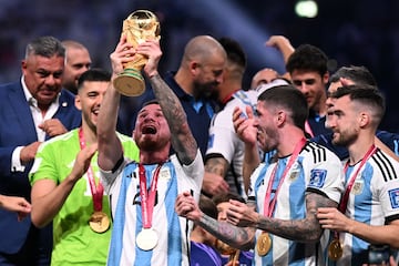 Argentina's midfielder #20 Alexis Mac Allister lift the FIFA World Cup Trophy during the Trophy ceremony as he celebrates winning the Qatar 2022 World Cup final football match between Argentina and France at Lusail Stadium in Lusail, north of Doha on December 18, 2022. (Photo by Kirill KUDRYAVTSEV / AFP)